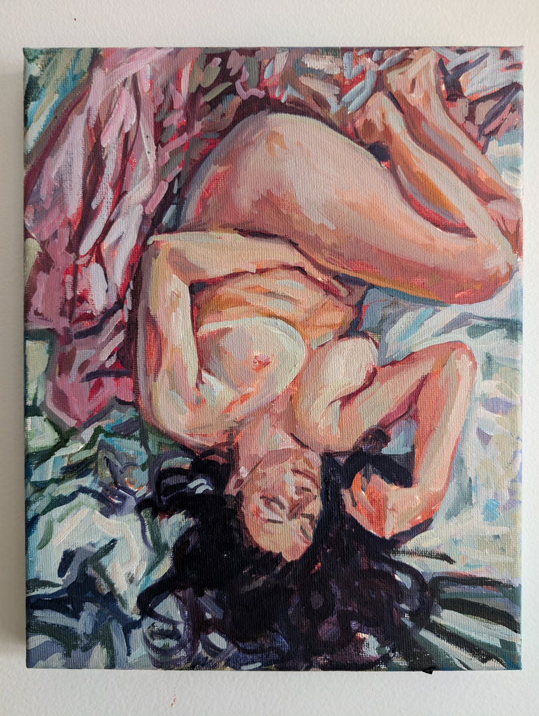 This image features a small, original oil painting that depicts a nude female figure, lying on a bed in a relaxed pose. The painting captures the subject with soft, warm colors and delicate strokes, emphasizing the figure's form and the gentle lighting that highlights her features. This is part of a series called Rebirth  exploring themes of body, self-image, aging, and womanhood.